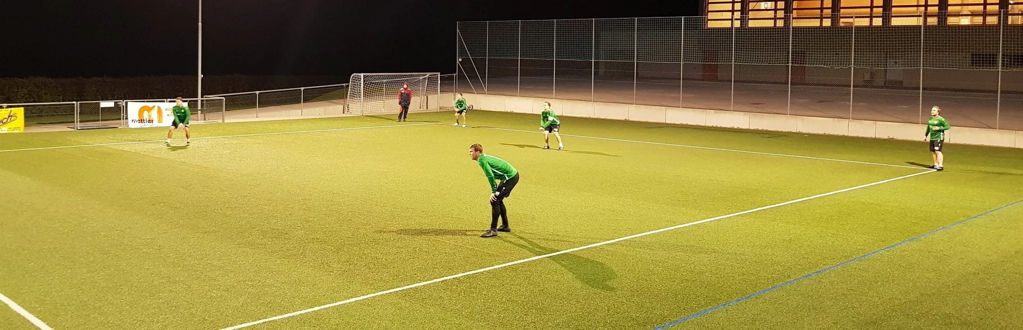 Faustballfeld unter Flutlicht bei Nacht