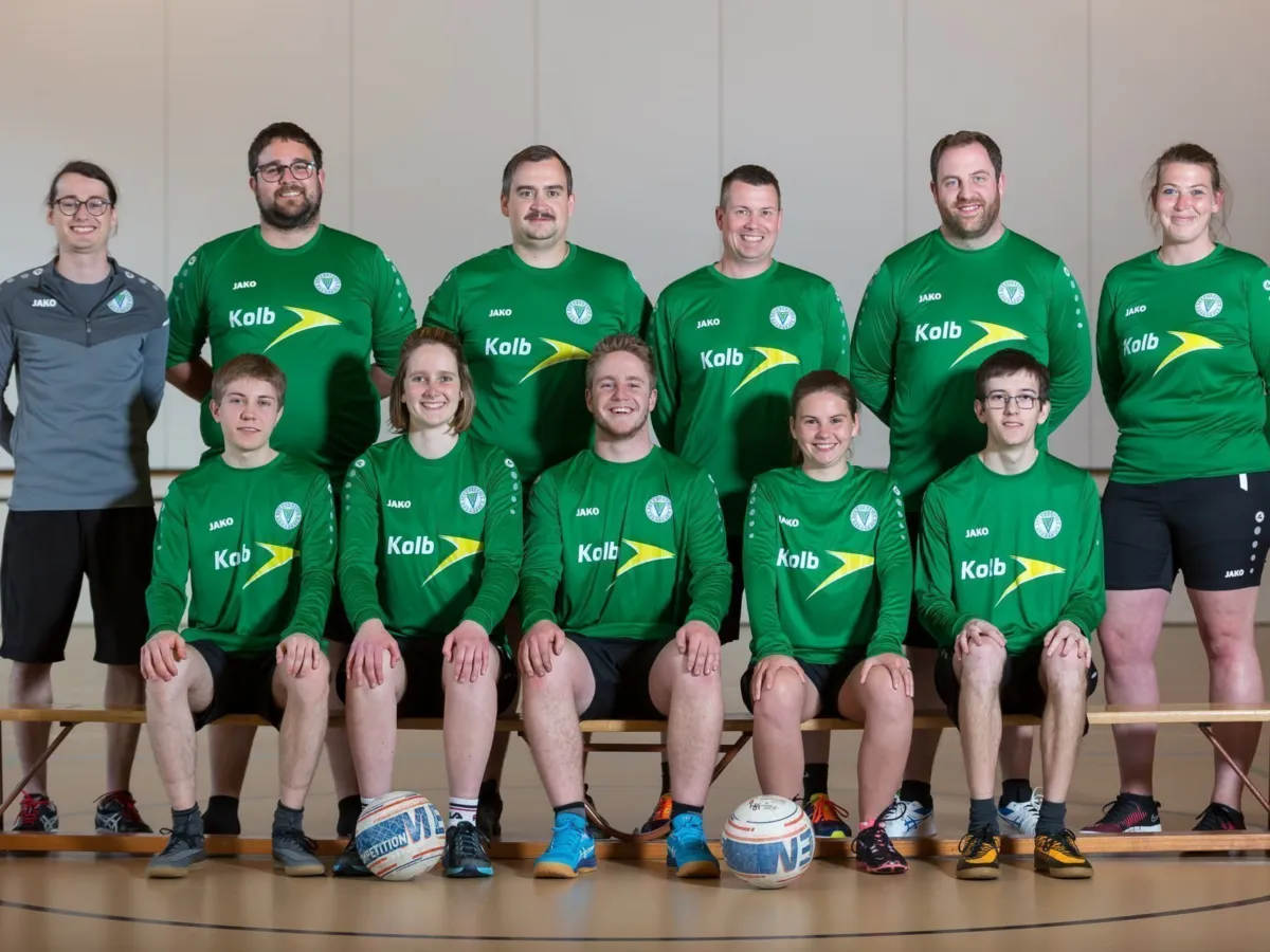Faustball Team 2 in grünen Trikots mit Bällen in der Halle