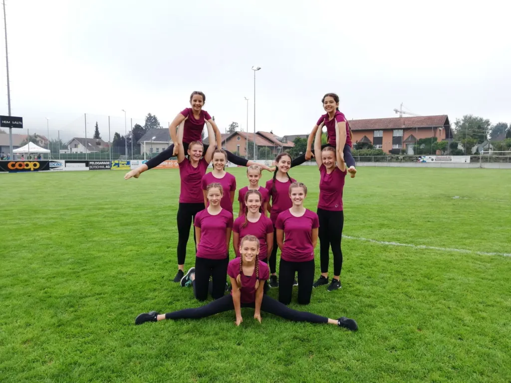 Die Jugend-Teamaerobic in einer Pyramide auf dem Rasen