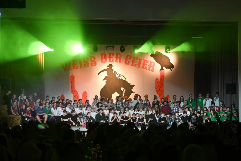 Schlussbild des Schauturnens auf der Bühne mit grüner Beleuchtung