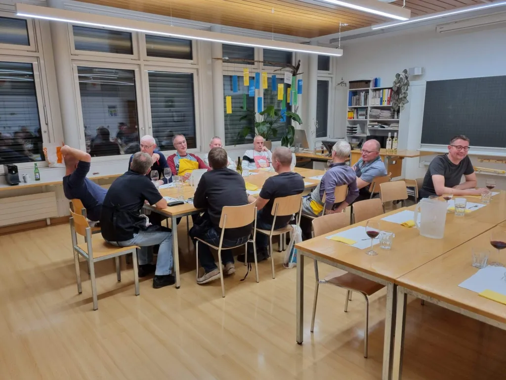 Männer der Männerriege beim gemeinsamen Essen an langen Tischen
