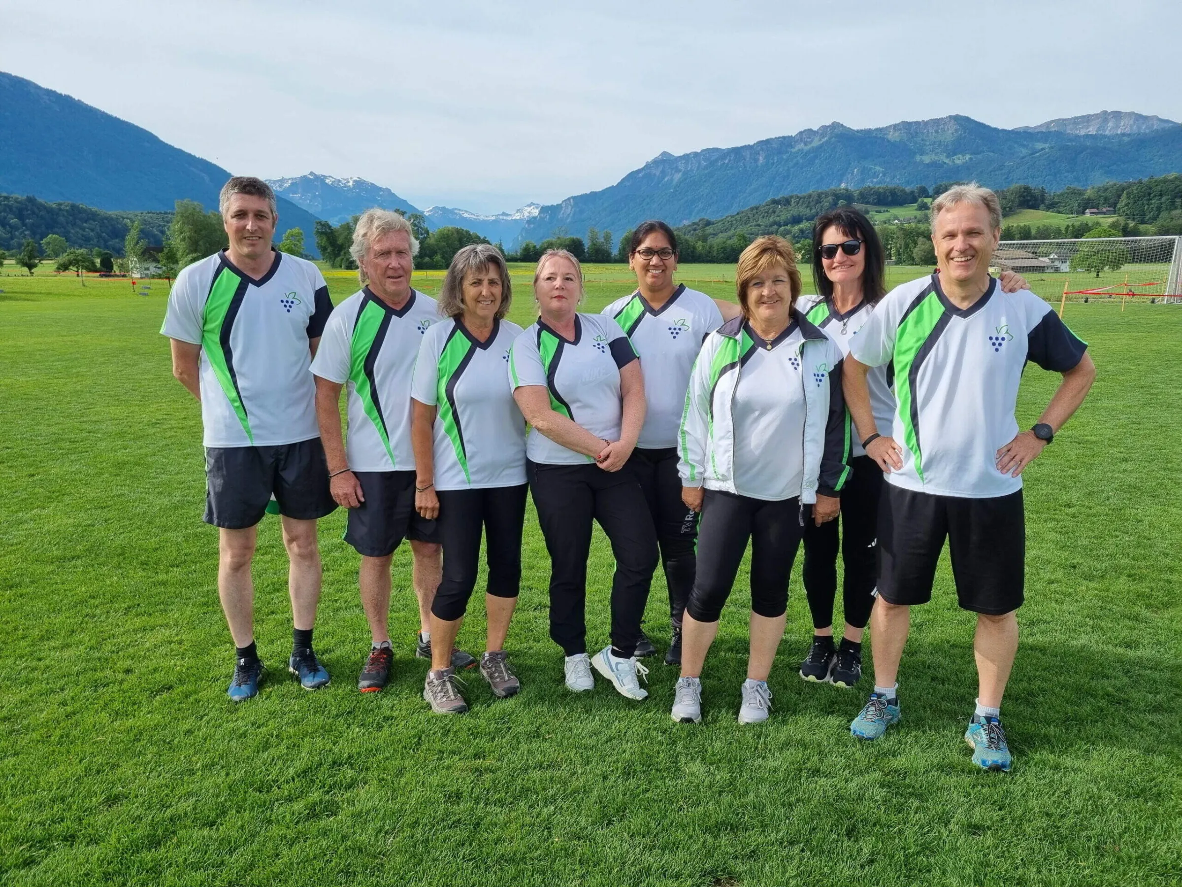 Frauen- und Männerriege in Vereinsshirts auf dem Sportplatz