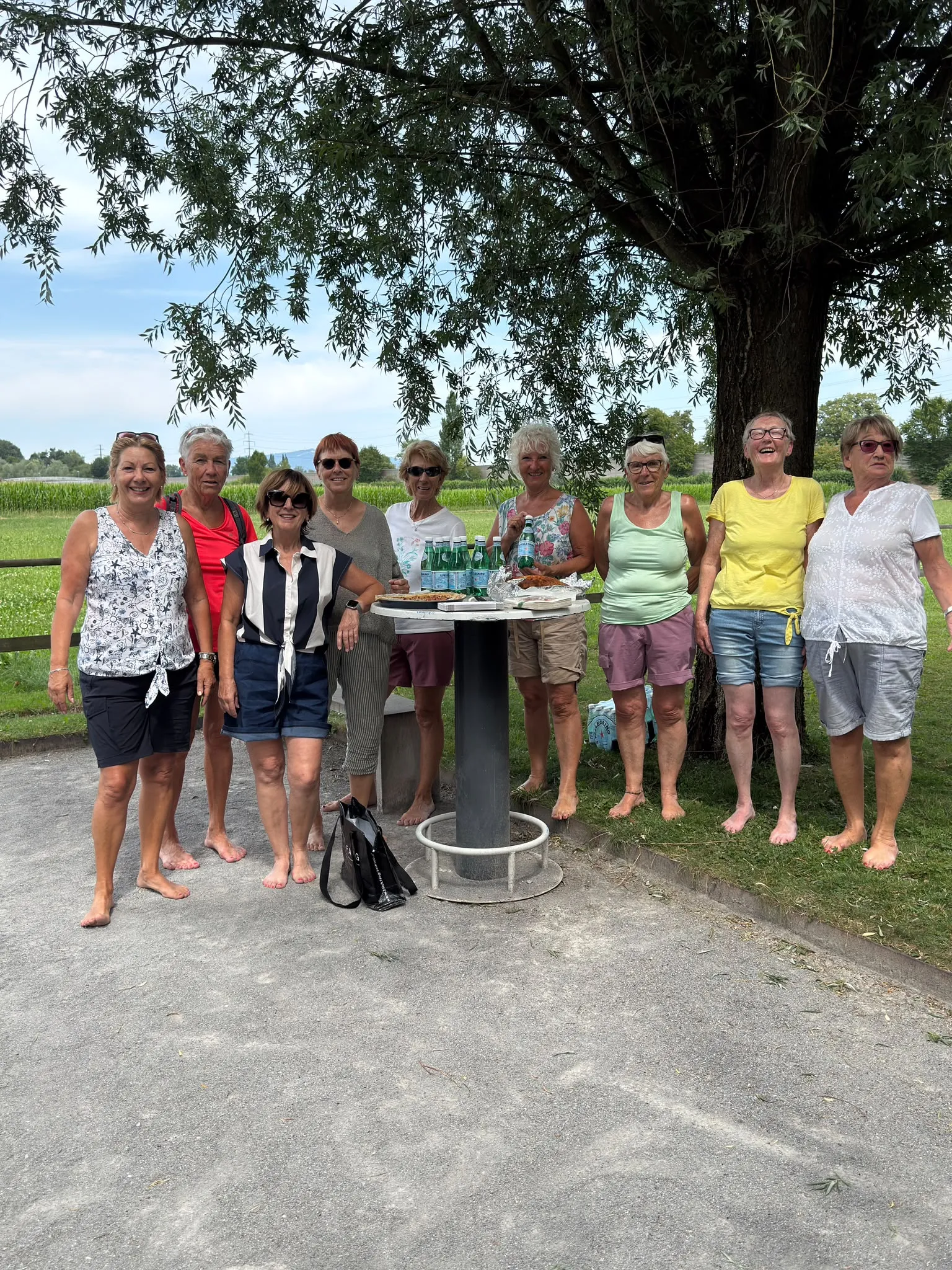 Acht Frauen der 60+ Riege an einem Rastplatz unter einem Baum